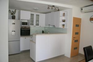 a kitchen with white cabinets and a counter top at Apartman Old Town in Trogir