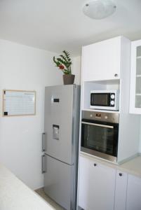 a kitchen with a refrigerator and a microwave at Apartman Old Town in Trogir