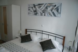 a bedroom with a white bed with two pillows at Apartman Old Town in Trogir