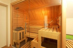 a sauna with a glass door and a tub at Lotsenstieg 04 in Ostseebad Karlshagen