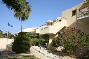 a building with a palm tree in front of it at Club Aphrodite in Erimi
