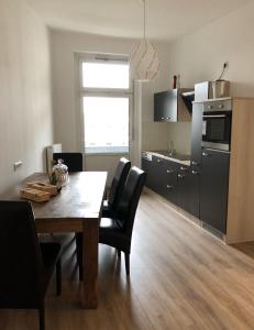 ヴッパータールにあるSchöne 3-Zimmer Wohnung im Herzen von Wuppertalのキッチン(木製テーブル、黒い椅子付)