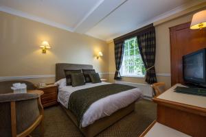 a bedroom with a large bed and a large window at Prince Rupert Hotel in Shrewsbury