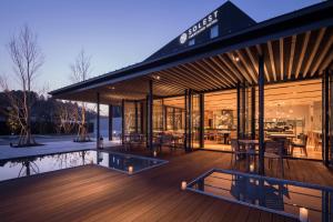 a house with a large deck with a pool at Solest Takachiho Hotel in Takachiho
