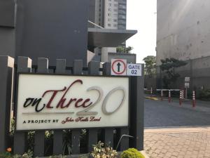 a sign on a fence next to a street at OnThree20 Araliya Apartment Colombo in Colombo