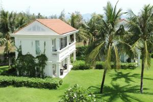 an aerial view of a white house with palm trees at Boutique Hoi An Resort in Hoi An