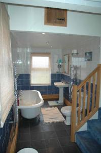 a bathroom with a tub and a toilet and a sink at Mid Wales Arts B&B in Caersws