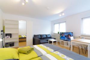 ein Schlafzimmer mit einem Bett, einer Couch und einem Fernseher in der Unterkunft Private rooms next to subway in Nürnberg