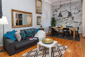 een woonkamer met een bank en een tafel bij Designer Apartment Eclectica in Belgrado
