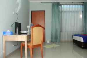 um quarto com uma secretária, uma cadeira e uma cama em RedDoorz @ Sersan Bajuri em Bandung