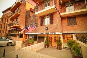 un edificio de ladrillo con banderas americanas delante de él en Tbilisi View Hotel en Tiflis