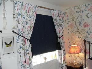 una ventana en una habitación con una cortina con mariposas en Jessop House en Tewkesbury