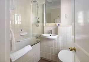 uma casa de banho branca com um lavatório e um chuveiro em The Berkeley Square Hotel Bristol em Bristol
