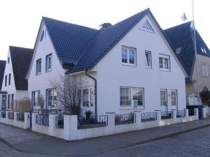 ノルダーナイにあるStrandflieder Backbordの黒屋根の大白い家