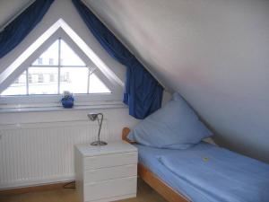 ノルダーナイにあるStrandflieder Backbordのベッドルーム(ベッド1台、窓付)