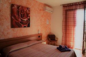 1 dormitorio con 1 cama y una pintura en la pared en B&B Marina, en Castro di Lecce