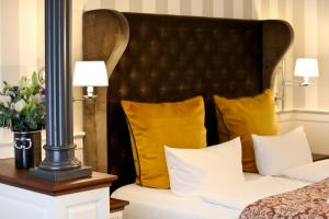 a hotel room with a bed with yellow pillows at Europa Hotel Kühlungsborn in Kühlungsborn