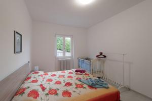 1 dormitorio con 1 cama con colcha de flores en Villa Bianca, en Varenna