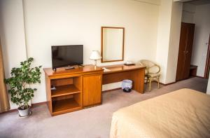 a bedroom with a desk with a television and a mirror at Hotel Seven in Cluj-Napoca