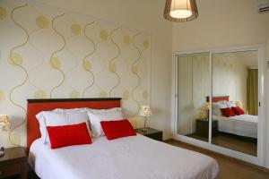 a bedroom with a large white bed with red pillows at Club Aphrodite in Erimi