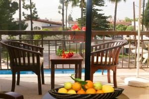 two chairs and a bowl of fruit on a balcony at Club Aphrodite in Erimi