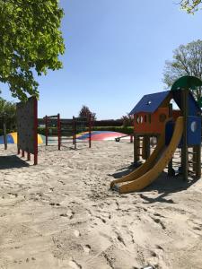 a playground with a slide in the sand at HYGGE Strand Camping in Odder