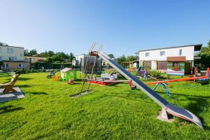 a playground with a slide in the grass at Bajka in Dąbki