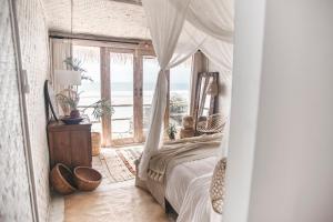 Schlafzimmer mit Himmelbett und Meerblick in der Unterkunft Dreamsea Bali in Uluwatu