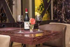una mesa con dos copas de vino y una botella de vino en La Voglia Hotel Boutique, en Tirana