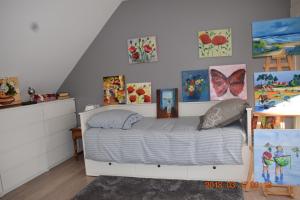 a bedroom with a bed with paintings on the wall at Les Tilleuls in Ballan-Miré