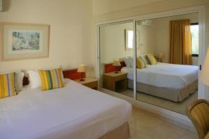a hotel room with two beds and a mirror at Club Aphrodite in Erimi