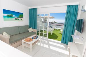 sala de estar con sofá y vistas al océano en Vista Oasis, en Maspalomas