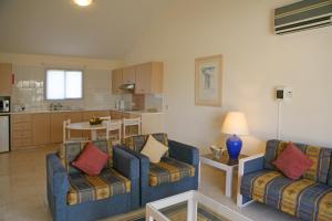 a living room with two couches and a kitchen at Club Aphrodite in Erimi