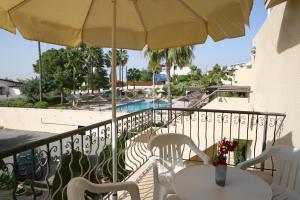 a balcony with a table and chairs and an umbrella at Club Aphrodite in Erimi