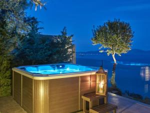 a jacuzzi tub on a patio with a lantern at Avra Luxury Villa & Spa in Keri