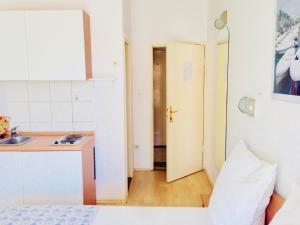 a room with a kitchen and a sink and a bed at Apartments Ruza in Kaštela