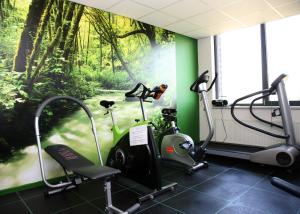 une salle de sport avec deux vélos d'exercice et une fresque murale. dans l'établissement Fletcher Hotel-Restaurant Zevenbergen-Moerdijk, à Zevenbergen