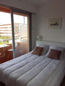 a large white bed in a room with a window at Maxime plage in Sainte-Maxime