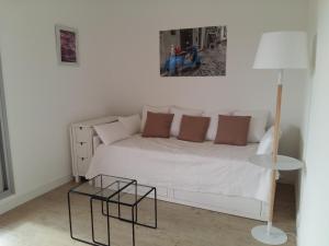 - une chambre avec un lit blanc et une lampe dans l'établissement Maxime plage, à Sainte-Maxime