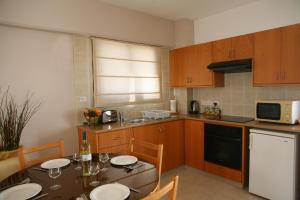 a kitchen with a table and chairs and a table and a kitchen with a table at Club Aphrodite in Erimi