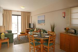 a kitchen and living room with a table and chairs at Club Aphrodite in Erimi