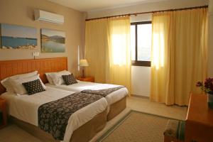 a hotel room with a bed and a window at Club Aphrodite in Erimi