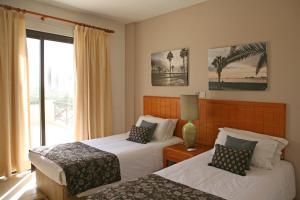 a hotel room with two beds and a balcony at Club Aphrodite in Erimi