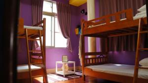 Un dormitorio con dos literas y una ventana. en HouseNandoor, en Tainan