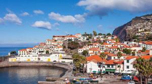 a group of houses on a hill next to the water at Atlantis Apartment in Câmara de Lobos