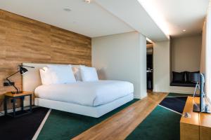 a bedroom with a white bed and a television at Octant Ponta Delgada in Ponta Delgada