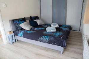 a bedroom with a bed with a blue comforter at kustappartementenkatwijk in Katwijk aan Zee