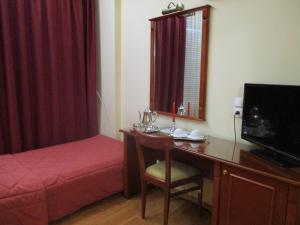 - une chambre avec un bureau, un lit et un sèche-cheveux dans l'établissement Hotel Delta, à Lamía