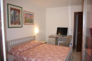 a bedroom with a bed and a desk with a computer at Affittacamere la Genzianella in Vinadio