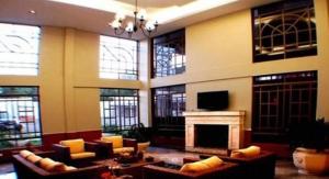 a large living room with a fireplace and a tv at Hotel Presidente in Uruguaiana